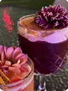 Cóctel de color violeta decorado con una flor